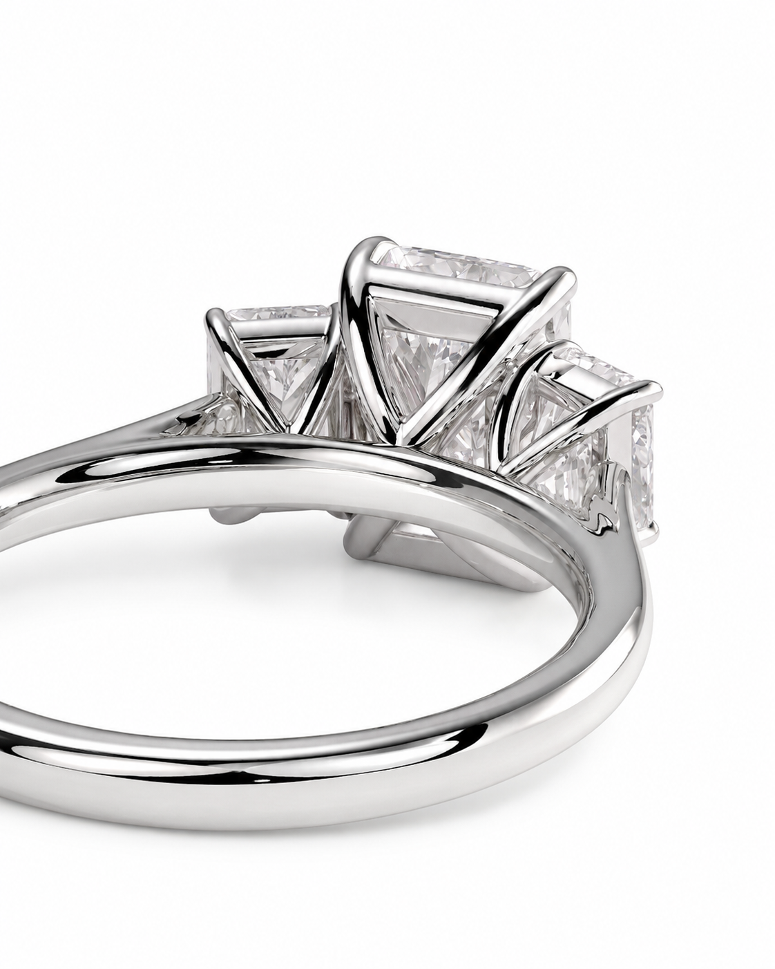 color_925_SIL,color_935_ARG,color_10K_WG, color_14K_WG &&A close-up studio shot of a silver-toned ring featuring a three-stone diamond cluster with rectangular and round-cut diamonds on a clean white background.