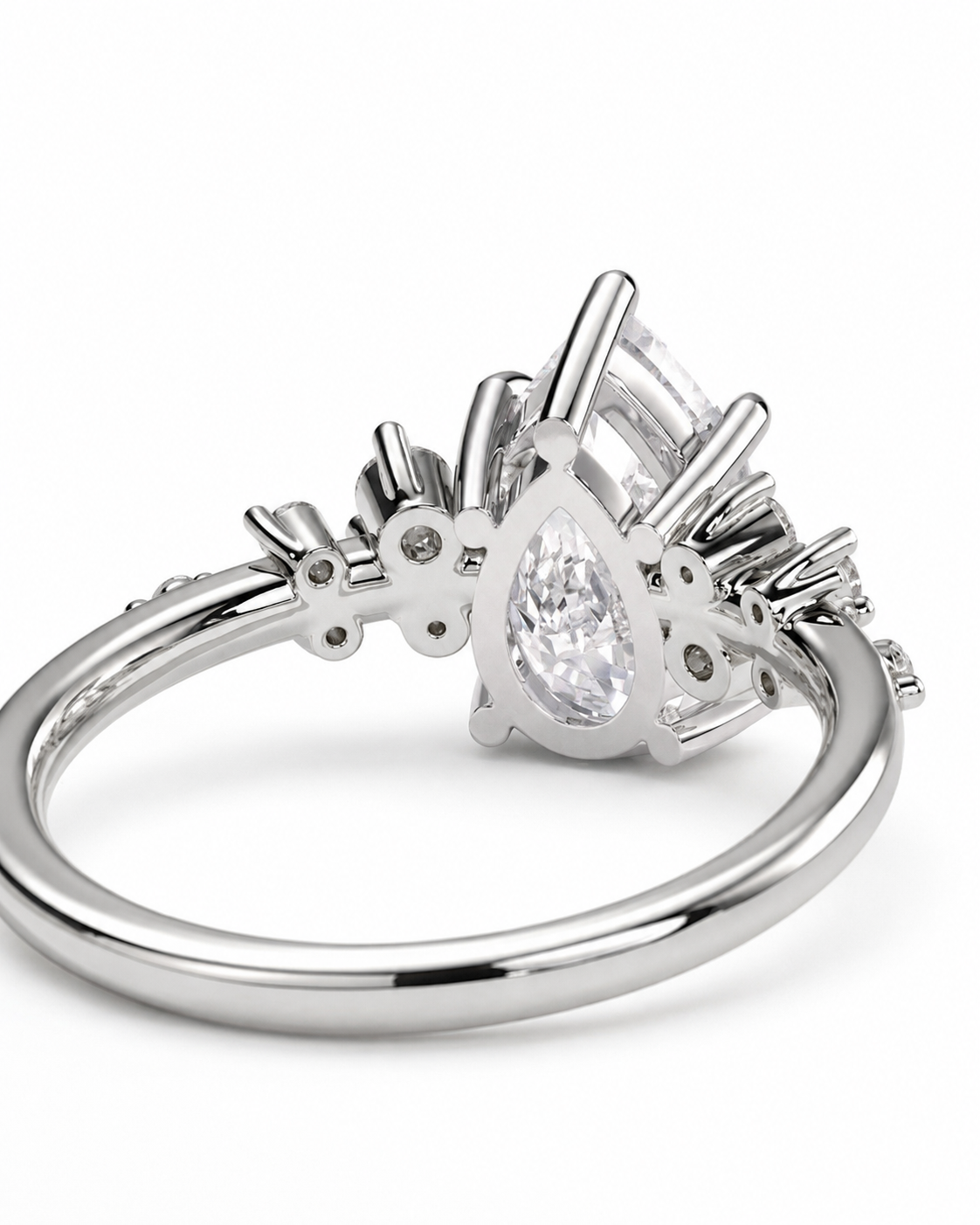 color_925_SIL,color_935_ARG,color_10K_WG, color_14K_WG &&A silver-toned diamond ring with a pear-cut center stone and smaller accent stones, shown on a clean white background.