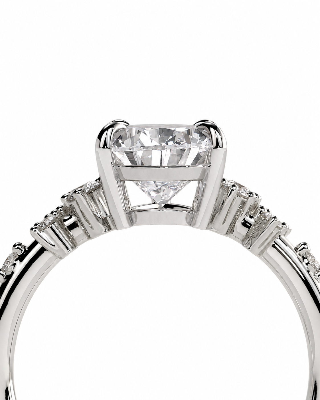 color_925_SIL,color_935_ARG,color_10K_WG, color_14K_WG &&A close-up studio shot of a silver-toned diamond ring featuring a large round brilliant-cut center stone in a four-prong setting, with smaller diamonds along the split shank, on a plain white background.