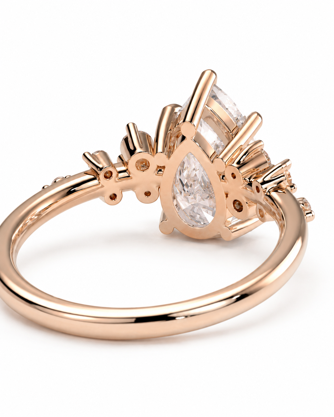 color_10K_RG, color_14K_RG &&Rose gold ring with a teardrop-cut clear center stone and smaller surrounding stones, shown on a clean white background.