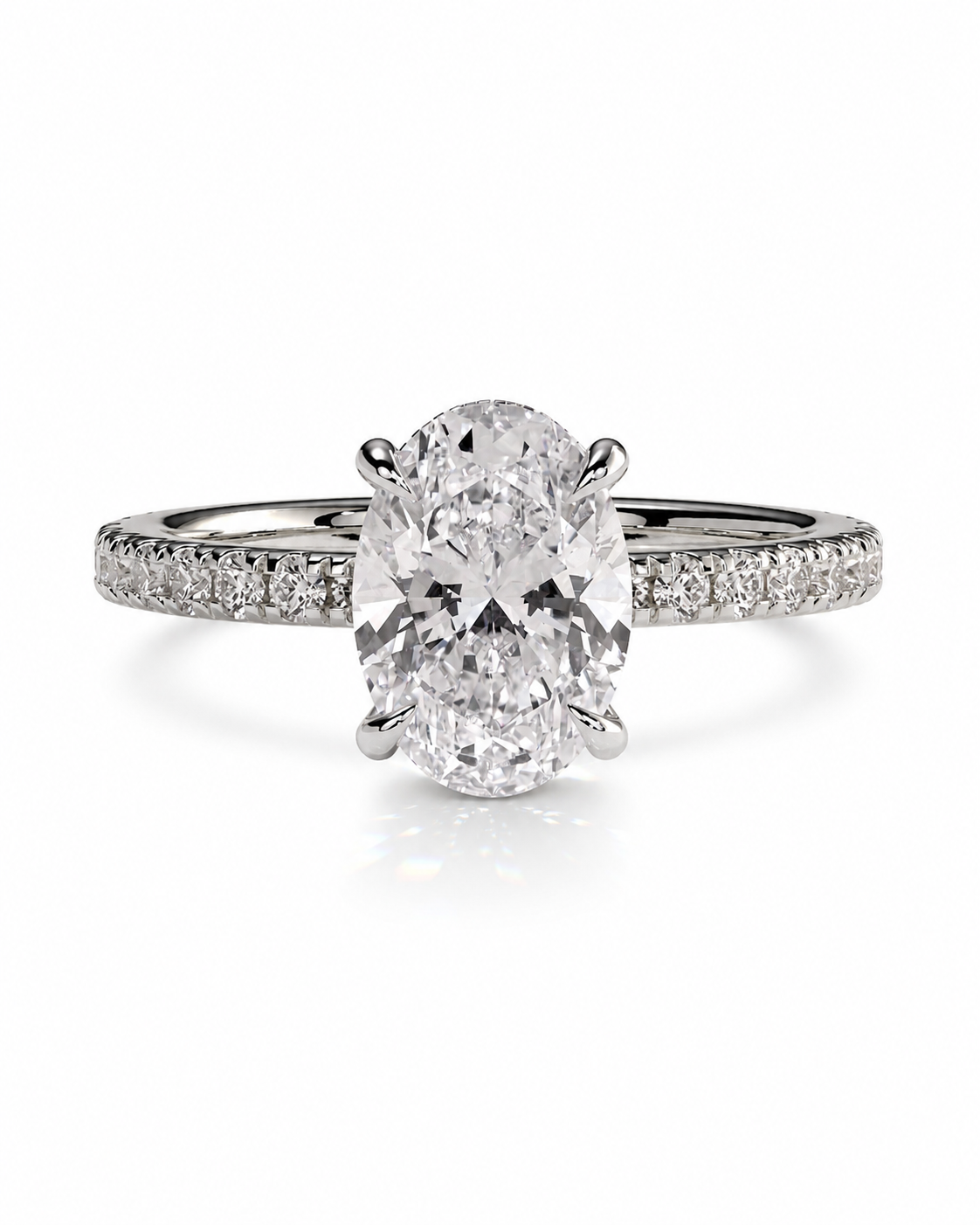 color_925_SIL,color_935_ARG,color_10K_WG, color_14K_WG &&An oval diamond engagement ring with a brilliant-cut center stone in a four-prong setting, featuring a pavé band set with smaller diamonds on a clean white background.