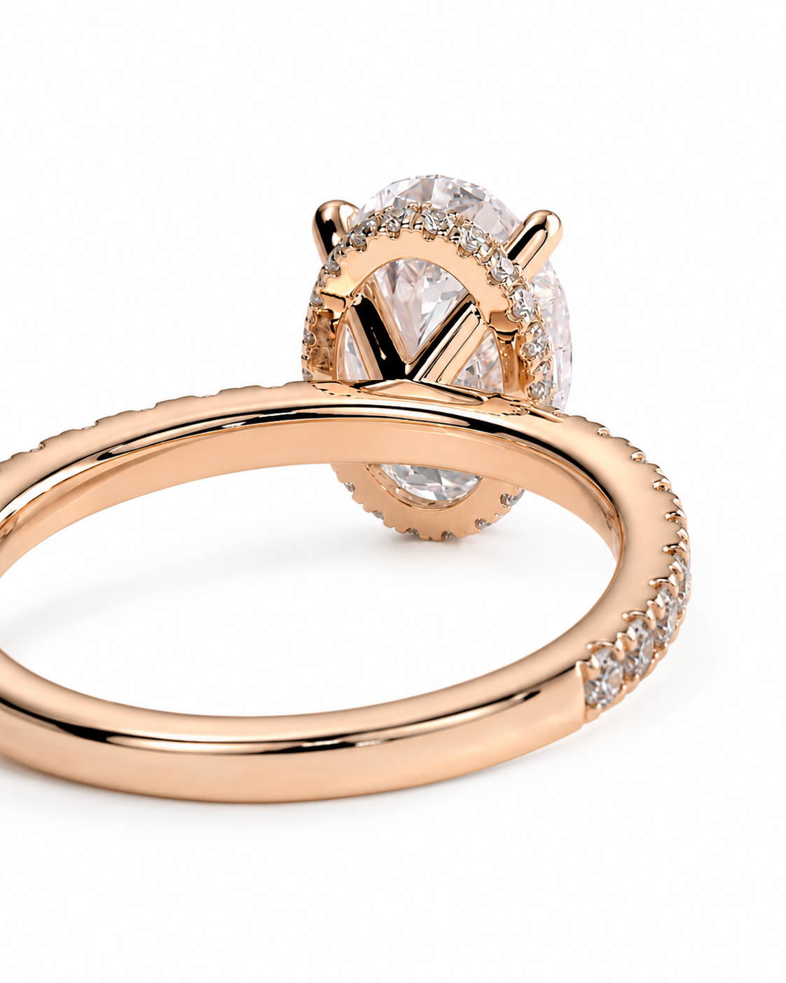 color_10K_RG, color_14K_RG &&A close-up of a rose gold ring with a large oval clear gemstone in a prong setting, surrounded by small pavé stones, on a white background.