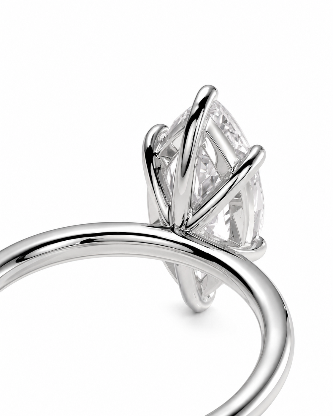 color_925_SIL,color_935_ARG,color_10K_WG, color_14K_WG &&A close-up studio shot of a silver-toned ring featuring a marquise-cut clear gemstone in a prong setting, shown against a plain white background.