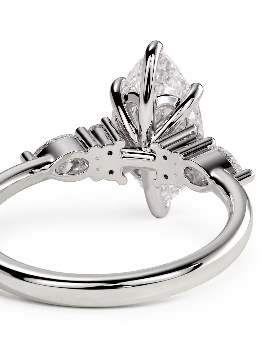 color_925_SIL,color_935_ARG,color_10K_WG, color_14K_WG &&A close-up studio shot of a silver-toned ring with a marquise-cut clear center stone and small side stones, shown against a plain white background.