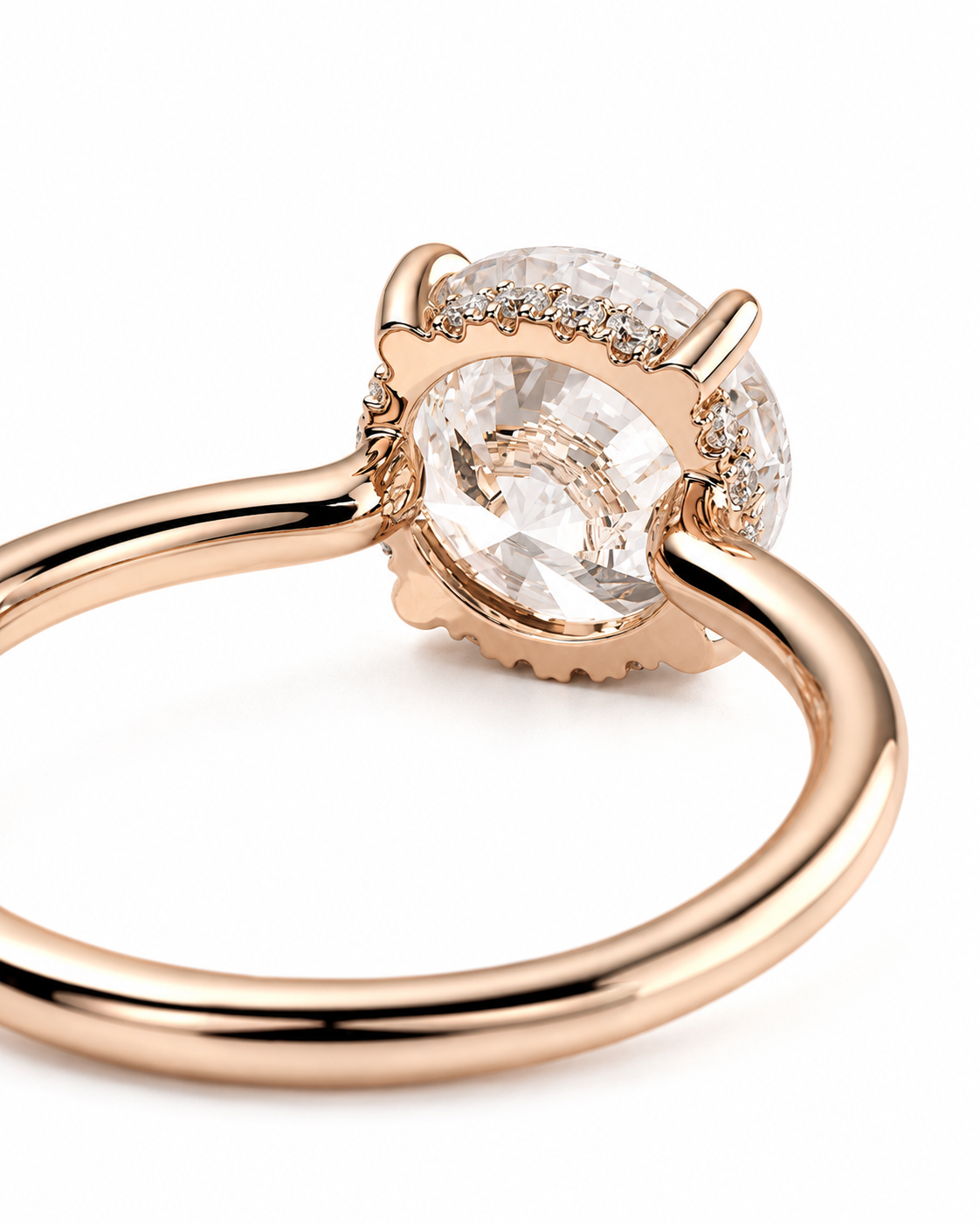 color_10K_RG, color_14K_RG &&A close-up of a rose gold ring featuring a large round clear gemstone in a prong setting, accented by smaller stones along the band, on a white background.