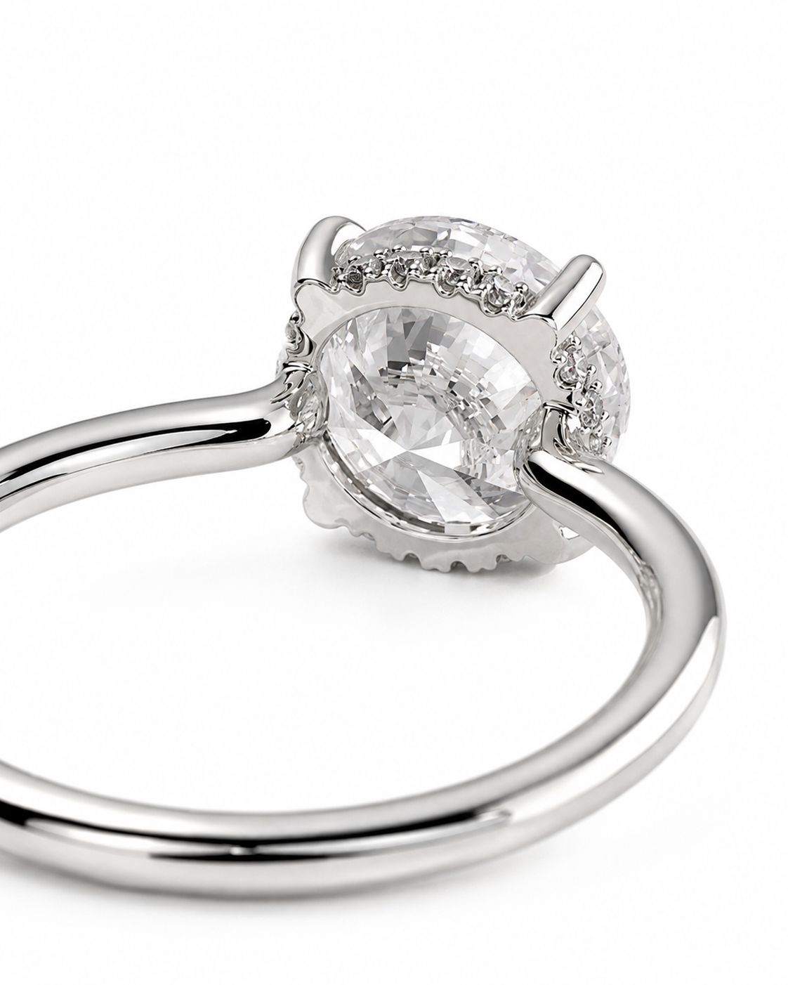 color_925_SIL,color_935_ARG,color_10K_WG, color_14K_WG &&A close-up shot of a silver-toned ring featuring a large oval clear gemstone in a prong setting, accented by small round stones along the halo, on a plain white background.