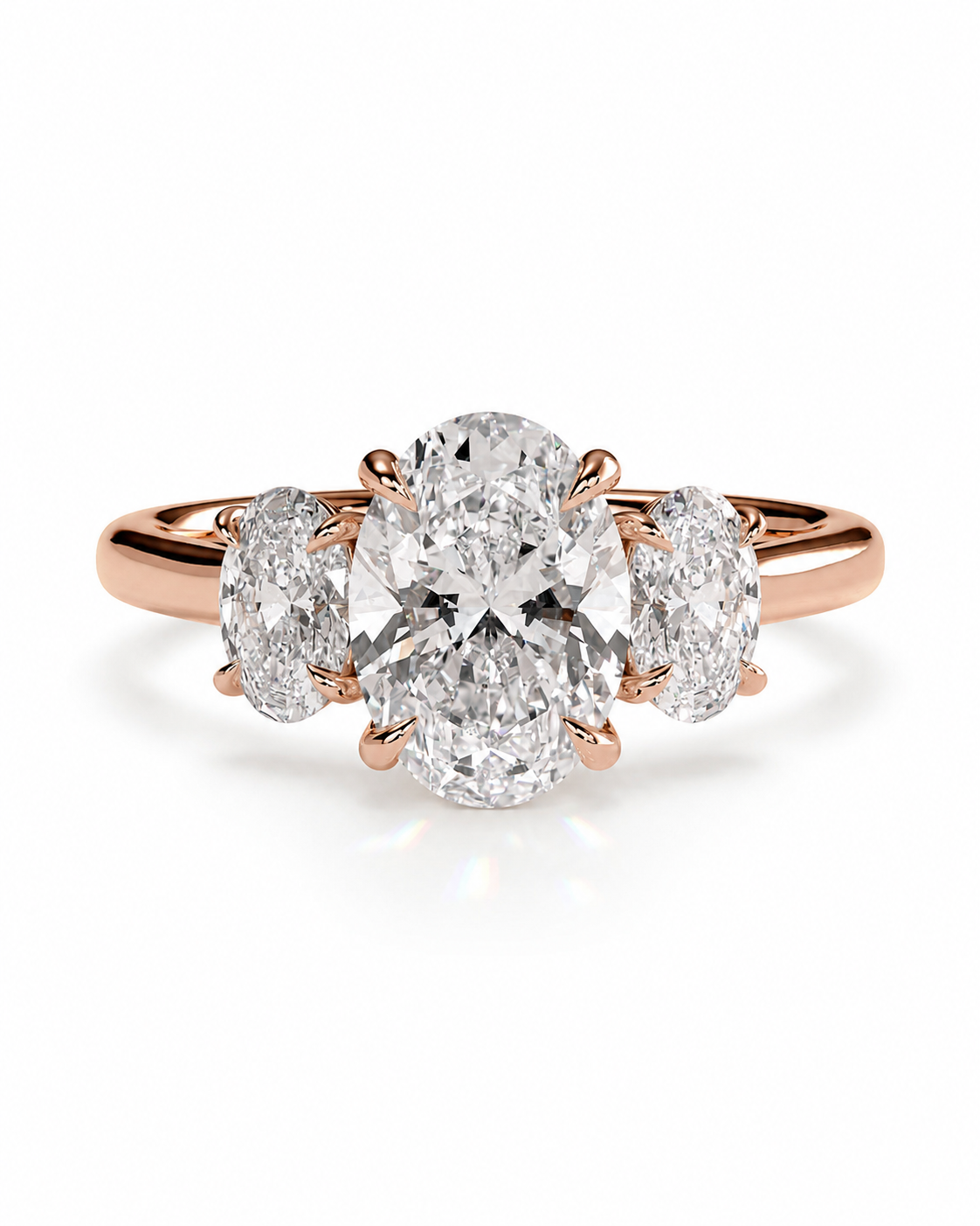 color_10K_RG, color_14K_RG &&A rose gold three-stone engagement ring featuring a large oval center diamond flanked by two smaller oval side diamonds, set against a clean white background.