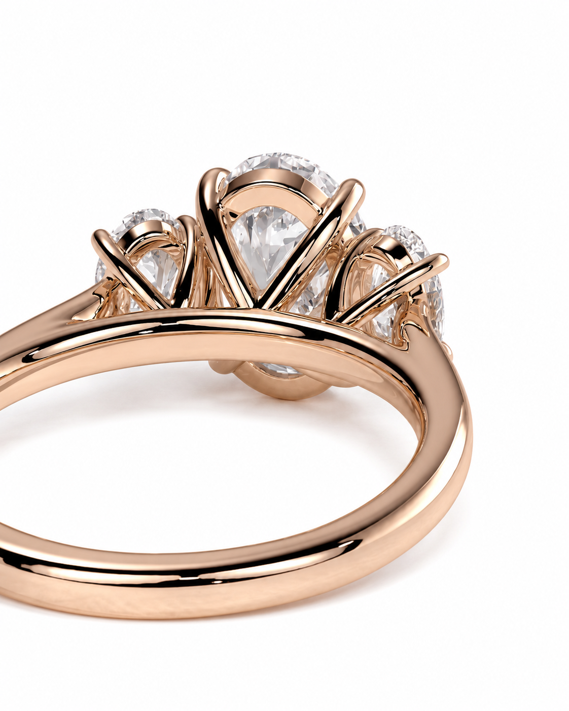 color_10K_RG, color_14K_RG &&A close-up of a rose gold ring featuring a central pear-cut clear gemstone surrounded by smaller round-cut stones, set on a polished band against a white background.