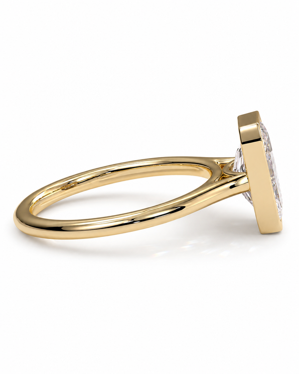 color_10K_YG, color_14K_YG &&A close-up side view of a yellow gold ring with a square bezel setting holding a clear gemstone, set against a clean white background.