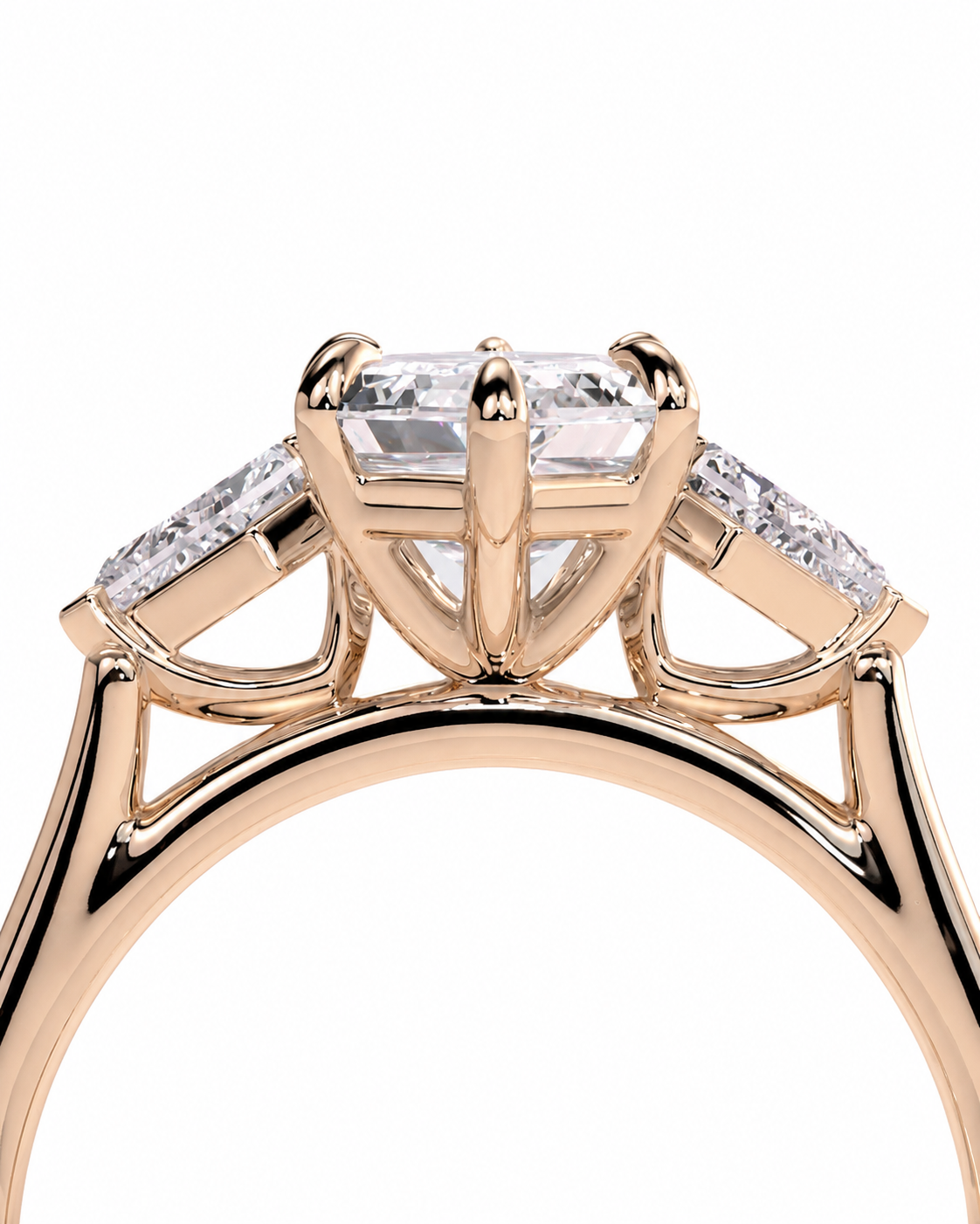 color_10K_RG, color_14K_RG &&A close-up of a rose gold engagement ring featuring a large rectangular center stone and smaller side stones, shown against a plain white background.
