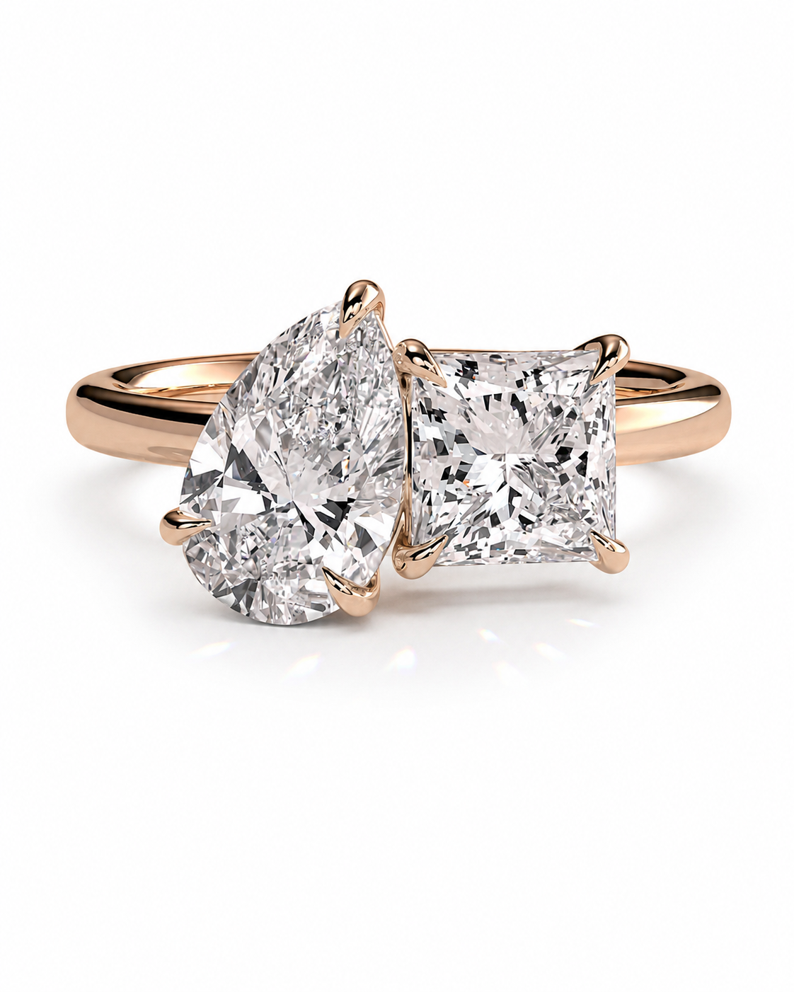 color_10K_RG, color_14K_RG &&A rose gold engagement ring featuring a pear-cut diamond and a princess-cut diamond set in a four-prong setting on a polished band, shown on a clean white background.