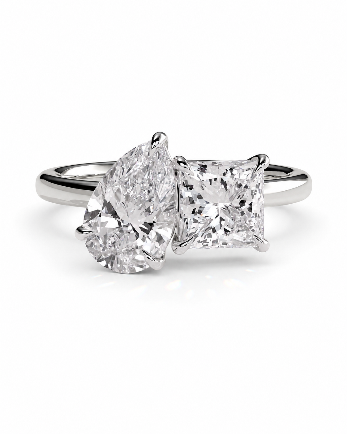 color_925_SIL,color_935_ARG,color_10K_WG, color_14K_WG && double-stone diamond ring featuring a pear-cut diamond and a princess-cut diamond set in a silver-colored band, shown on a clean white background.