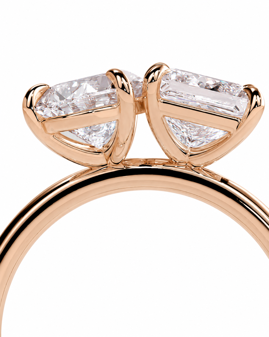 color_10K_RG, color_14K_RG &&A close-up of a rose gold ring featuring two marquise-cut clear gemstones in a bow-like setting, mounted on a polished rose gold band against a white background.