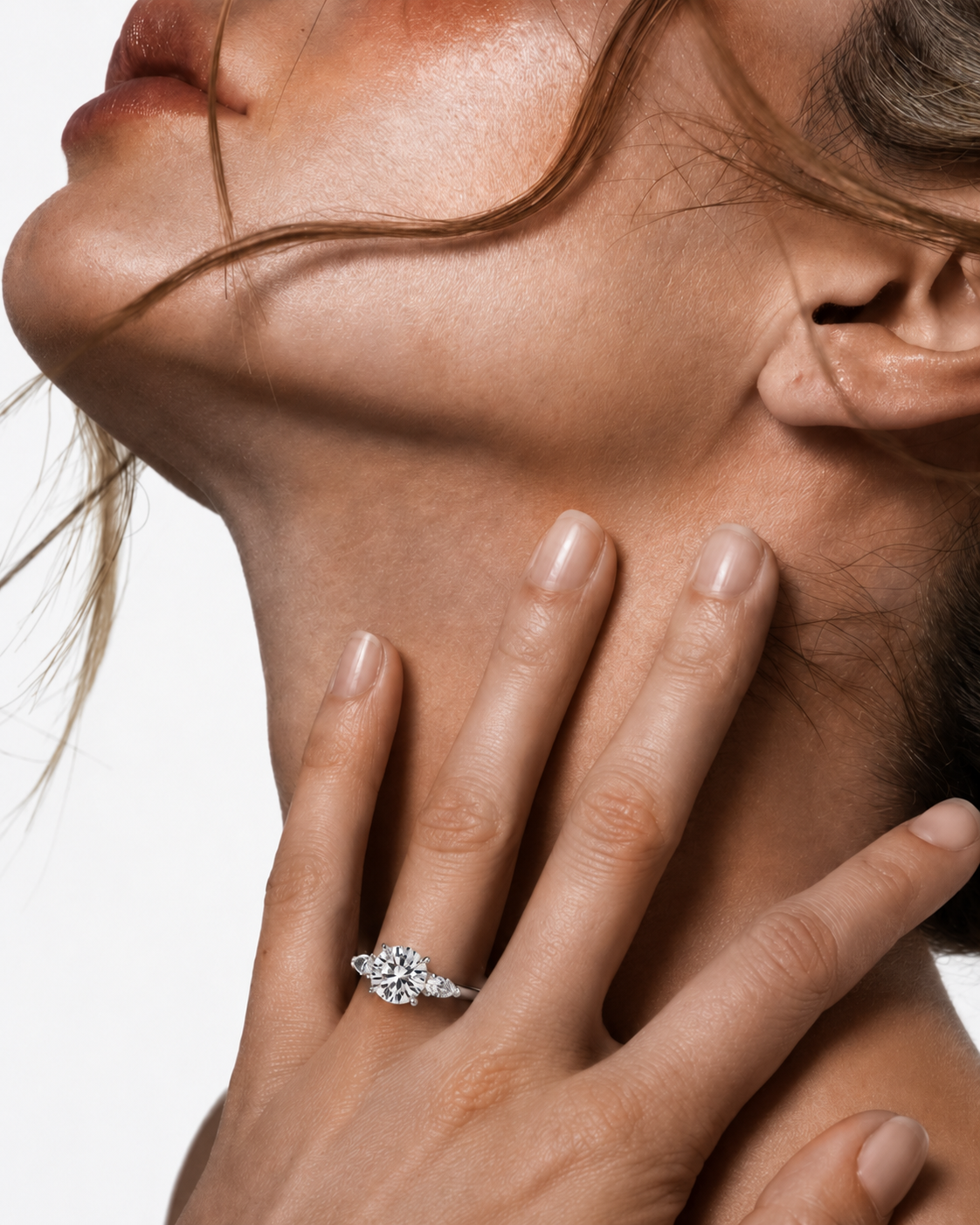color_925_SIL,color_935_ARG,color_10K_WG, color_14K_WG &&A close-up lifestyle shot of a model wearing a silver-toned diamond ring on her finger, with her hand resting on her neck against a clean white background.