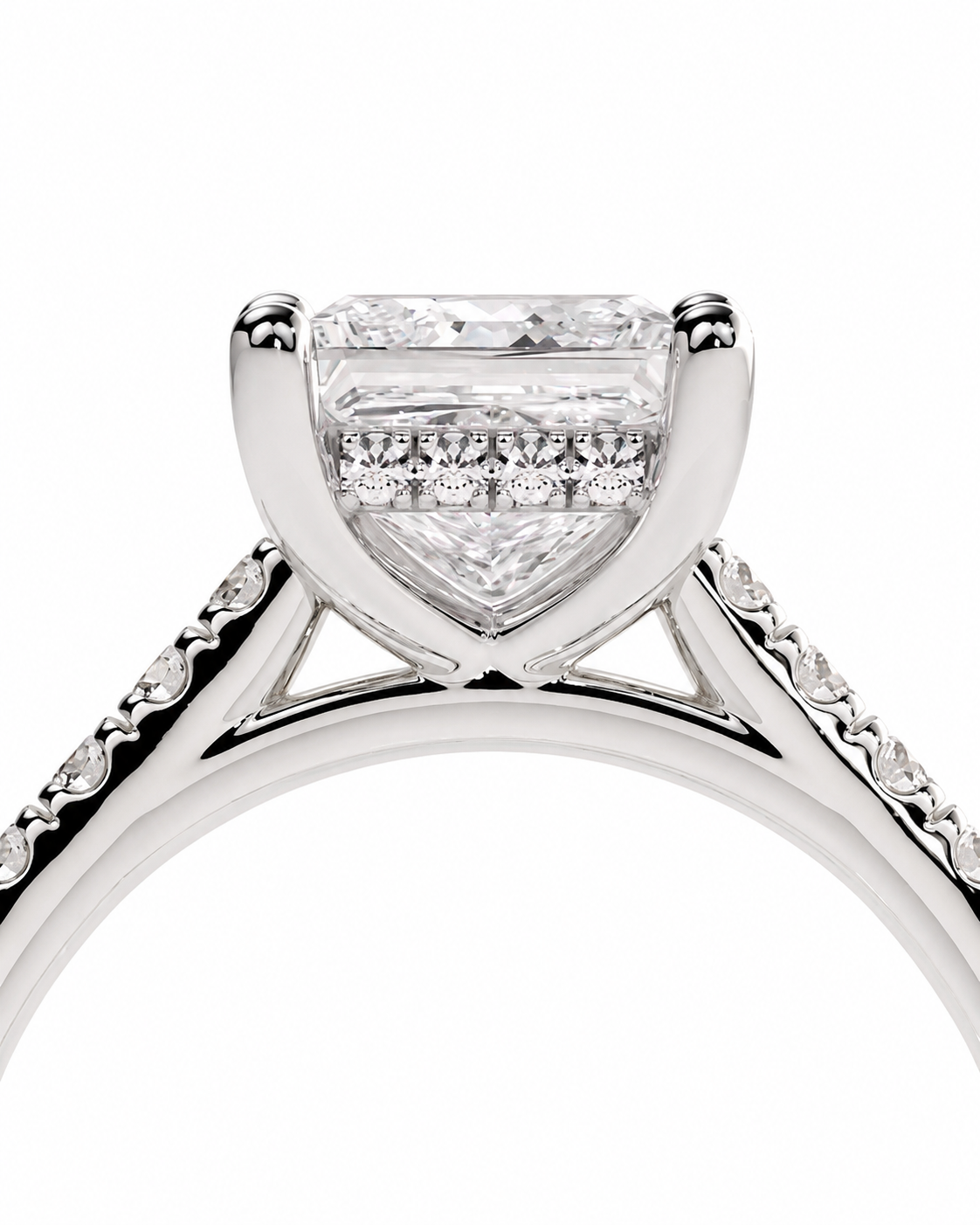 color_925_SIL,color_935_ARG,color_10K_WG, color_14K_WG &&A close-up studio shot of a diamond engagement ring showing a rectangular princess-cut center stone in a four-prong setting, with pavé diamonds along the shoulders of a polished silver-colored band.