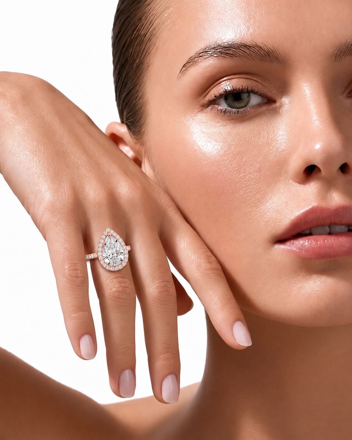 color_10K_RG, color_14K_RG &&A close-up lifestyle shot of a model wearing a teardrop-shaped diamond ring on her finger, with her hand resting against her cheek against a clean white background.