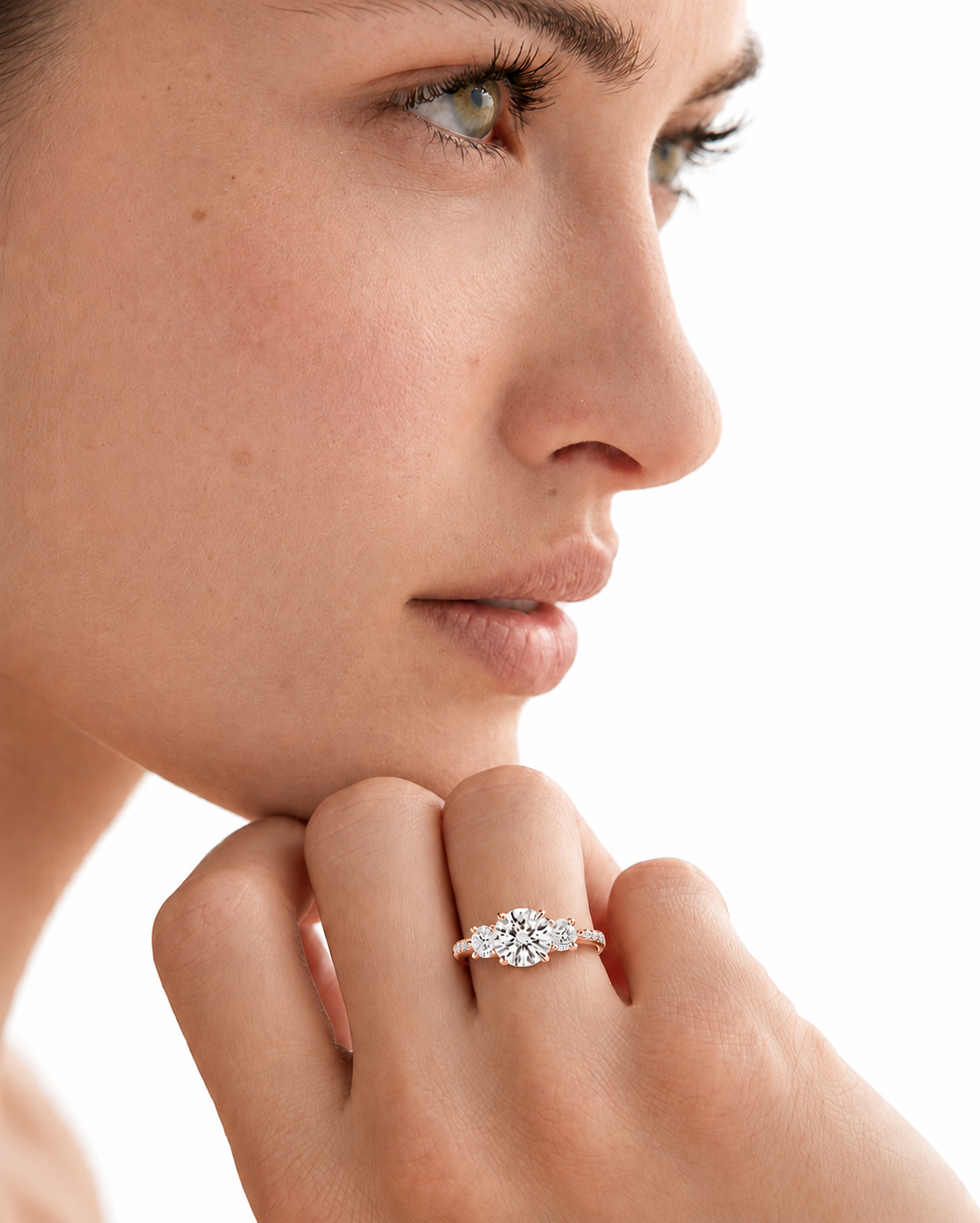 color_10K_RG, color_14K_RG &&A close-up side profile of a woman wearing a silver-toned ring with a marquise-cut center stone and smaller side stones on her finger, against a bright white background.