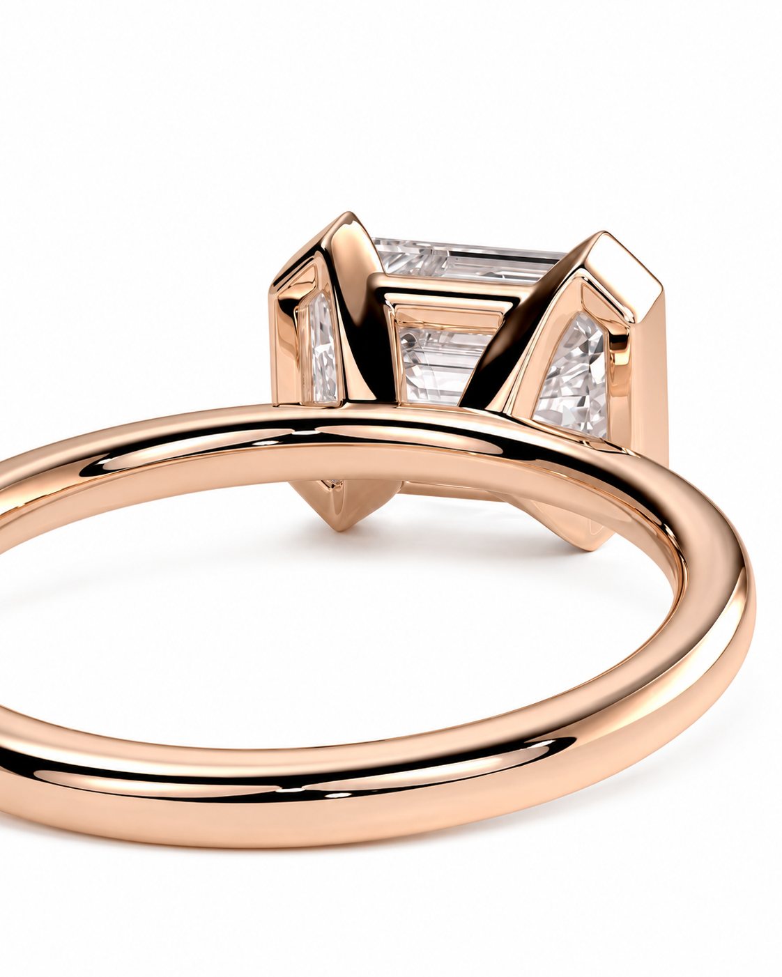 color_10K_RG, color_14K_RG &&Rose gold ring with a baguette-cut clear center stone and smaller side stones in a geometric setting, shown on a white background.