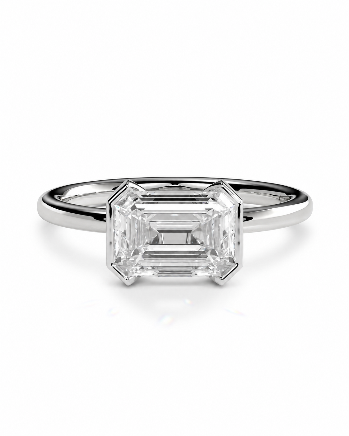 color_925_SIL,color_935_ARG,color_10K_WG, color_14K_WG &&An emerald-cut diamond engagement ring in a polished silver-colored metal band, shown on a clean white background with a soft reflection.