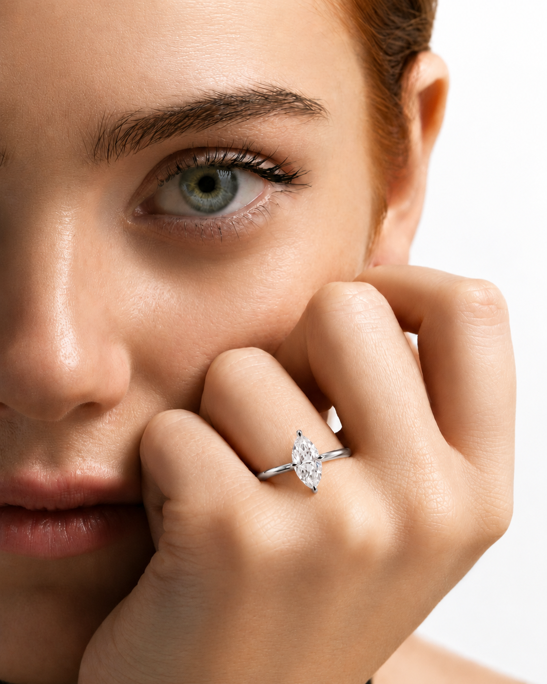color_925_SIL,color_935_ARG,color_10K_WG, color_14K_WG &&A close-up lifestyle shot of a model wearing a silver-toned ring with a marquise-cut clear gemstone on her finger, set against a clean white background.