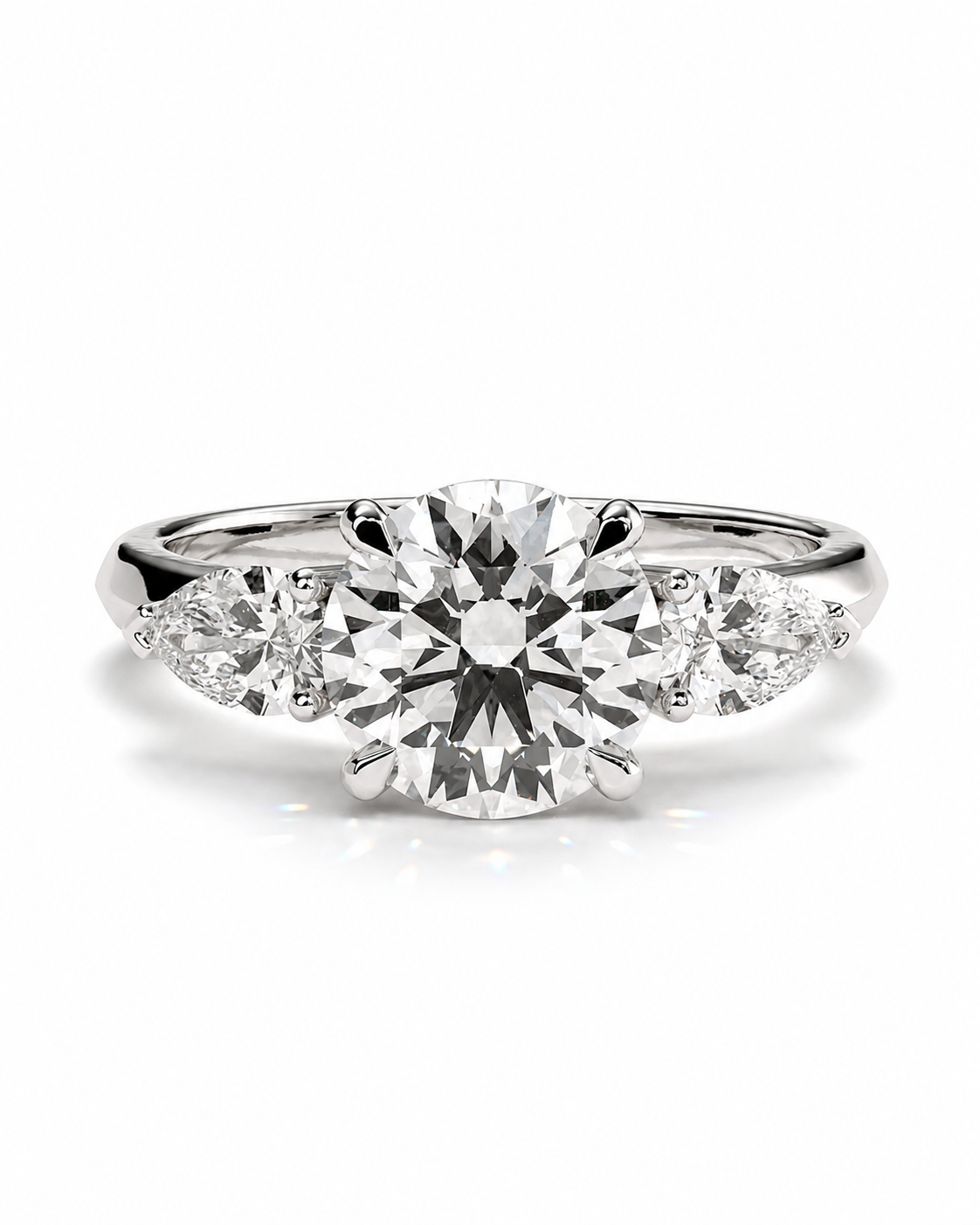 color_925_SIL,color_935_ARG,color_10K_WG, color_14K_WG &&A three-stone diamond engagement ring featuring a large round center diamond flanked by two smaller round diamonds on a polished silver-colored band, set against a clean white background.
