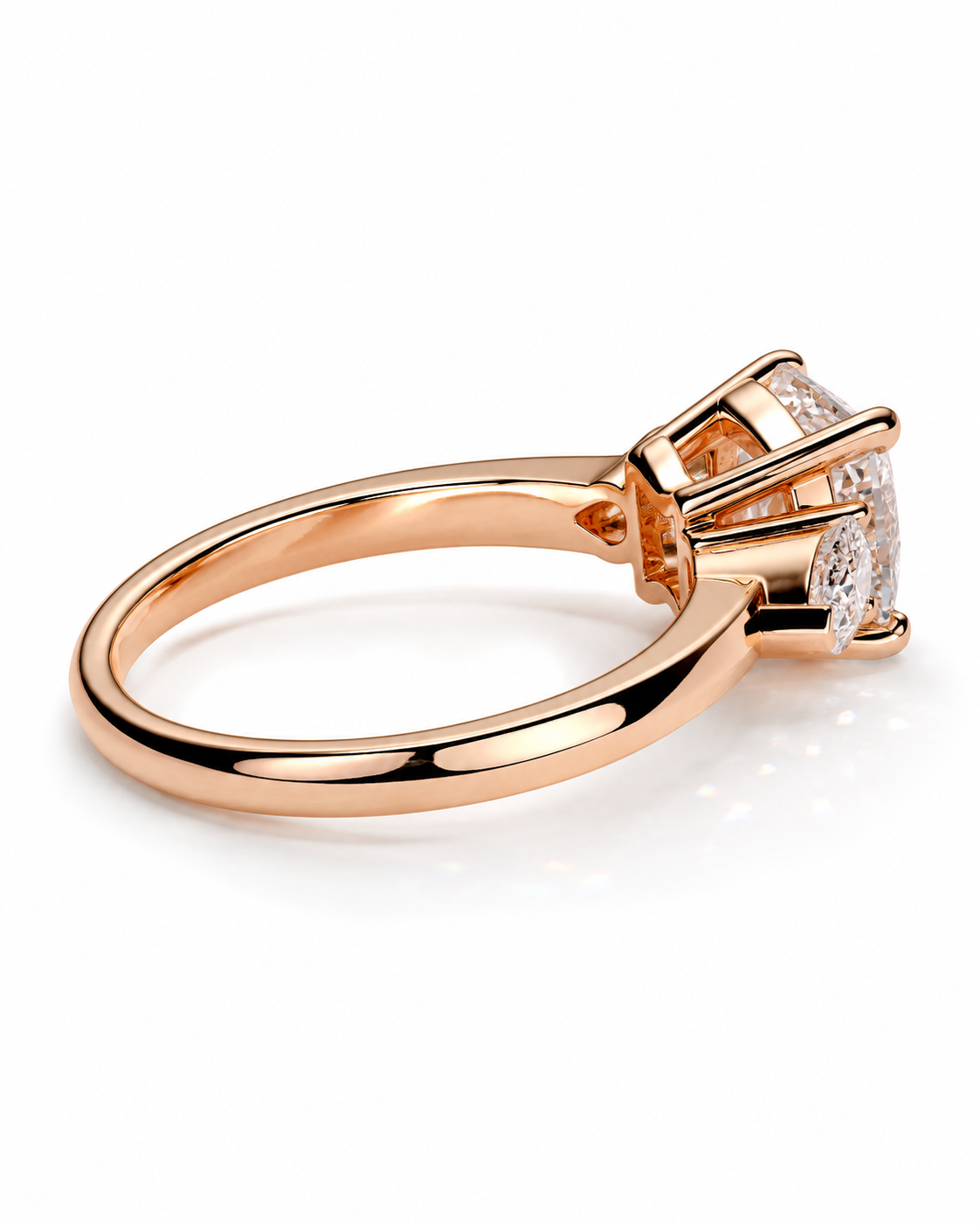 color_10K_RG, color_14K_RG &&Rose gold ring with a round-cut diamond in a three-stone setting, shown from a side angle on a white background.