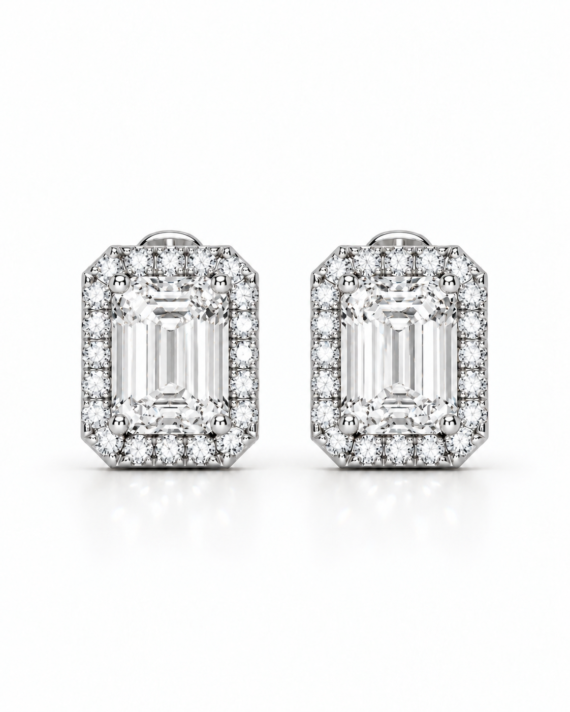 color_925_SIL,color_935_ARG,color_10K_WG, color_14K_WG &&A pair of rectangular emerald-cut halo stud earrings in silver-toned metal, featuring a central baguette-cut clear gemstone surrounded by smaller pavé-set stones, shown on a white background.