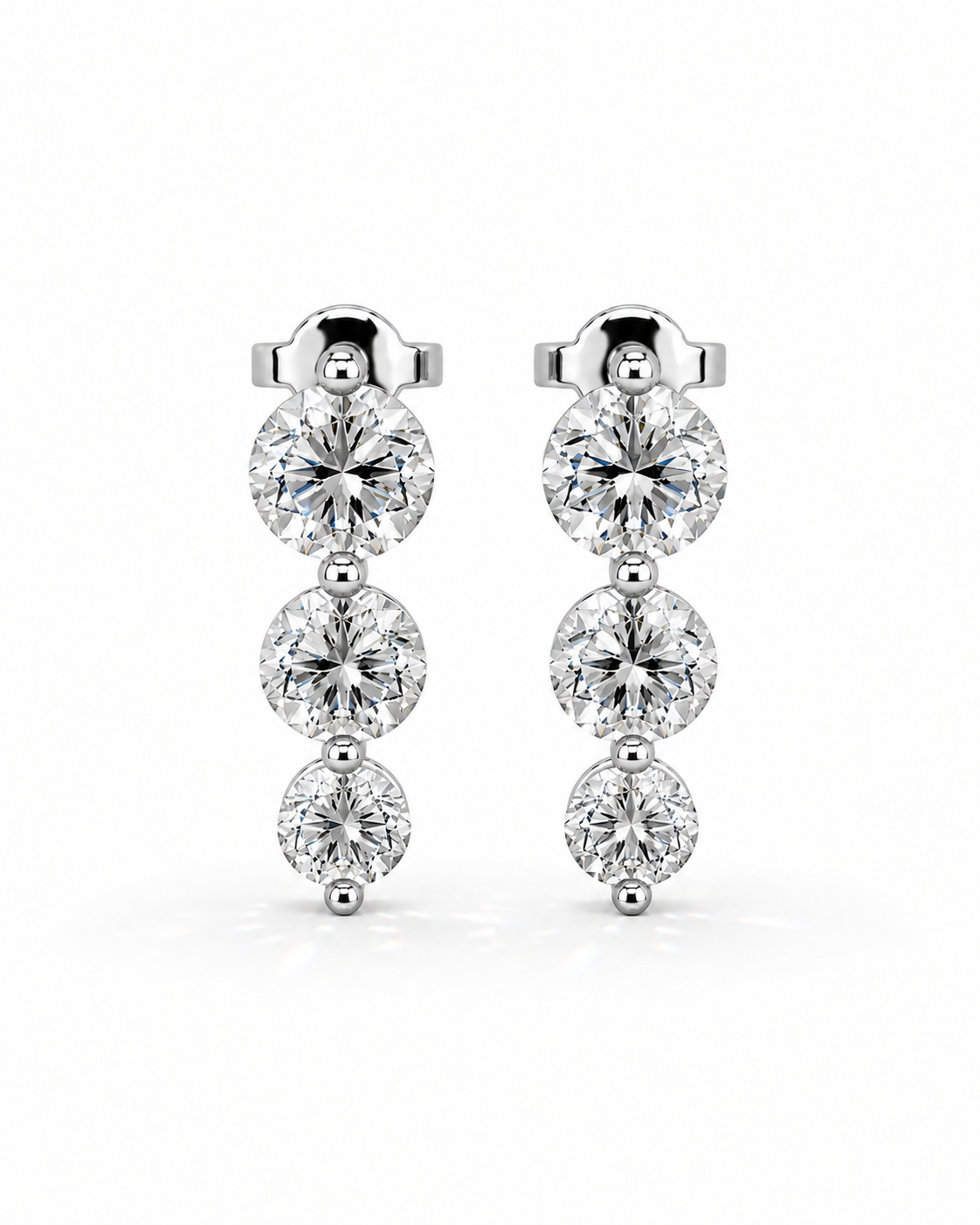 color_925_SIL,color_935_ARG,color_10K_WG, color_14K_WG &&A pair of silver drop earrings featuring three round-cut clear gemstones in each earring, set in a polished silver-tone metal against a clean white background.