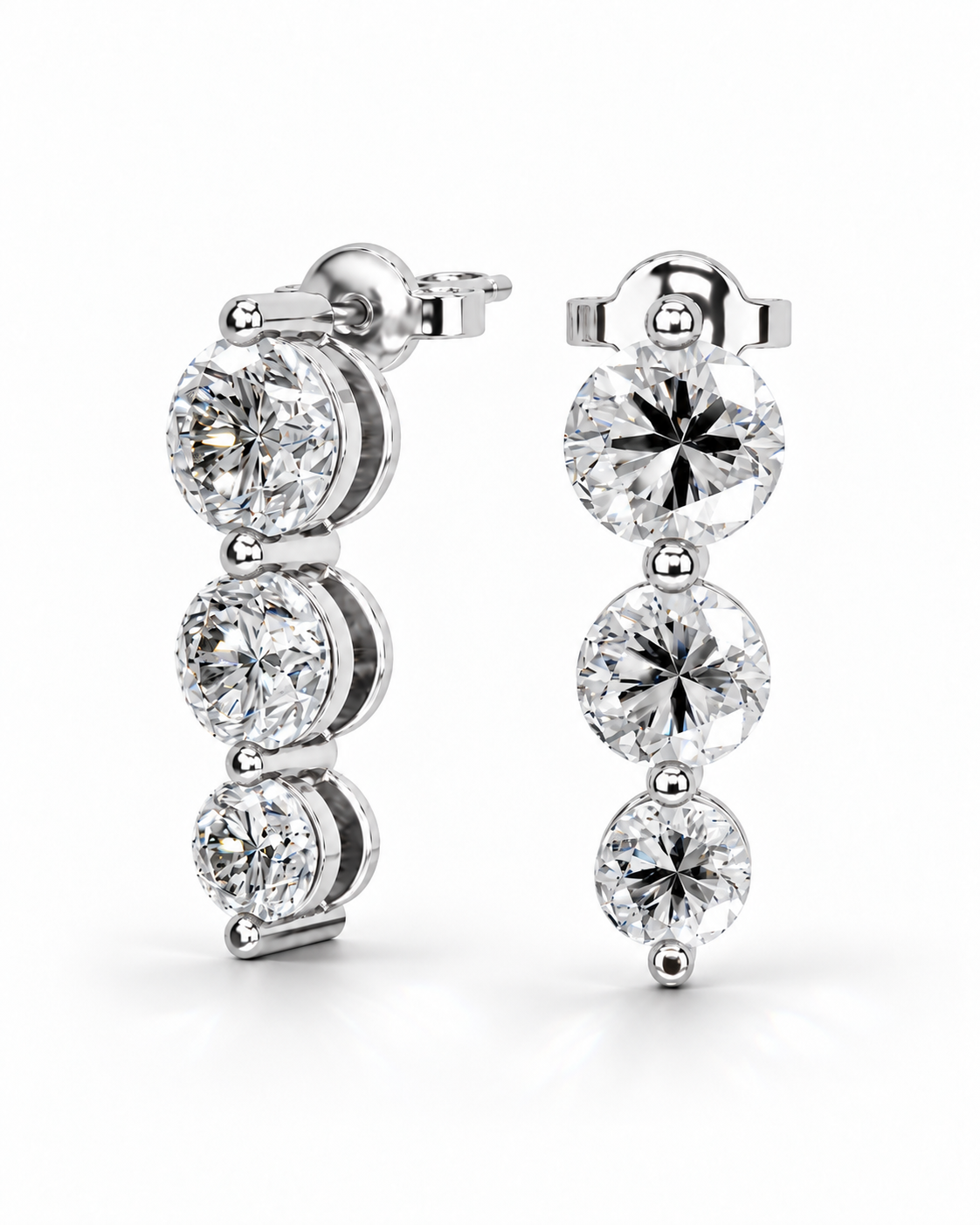 color_925_SIL,color_935_ARG,color_10K_WG, color_14K_WG &&A pair of silver-toned drop earrings with three round-cut clear gemstones in a vertical setting, shown on a clean white background.