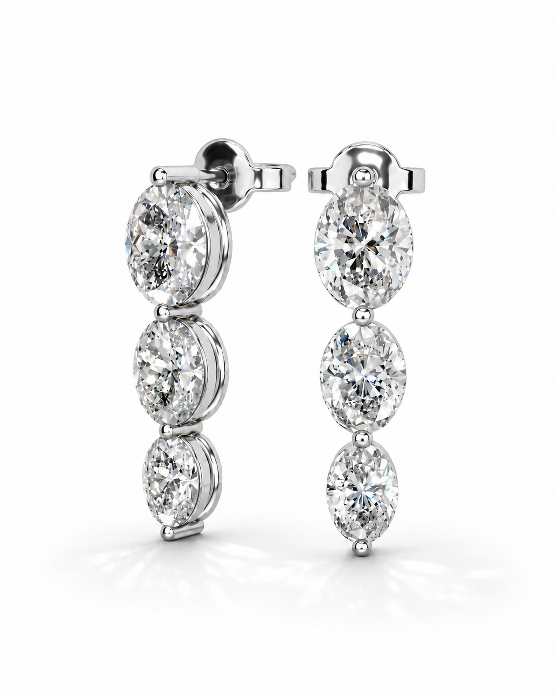 color_925_SIL,color_935_ARG,color_10K_WG, color_14K_WG &&A pair of silver-toned drop earrings featuring three vertically aligned oval-cut clear gemstones in prong settings, shown on a clean white background.