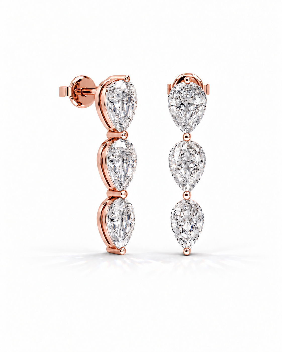 color_10K_RG, color_14K_RG &&A pair of rose gold drop earrings featuring three pear-cut clear gemstones in a vertical dangle design, set in polished rose gold on a clean white background.