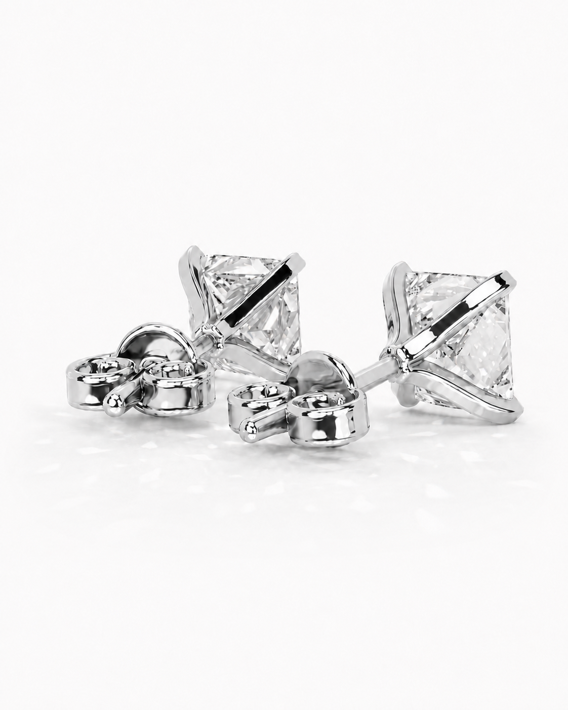 color_925_SIL,color_935_ARG,color_10K_WG, color_14K_WG &&A pair of silver stud earrings with clear rectangular gemstones, shown from a side angle on a clean white background.