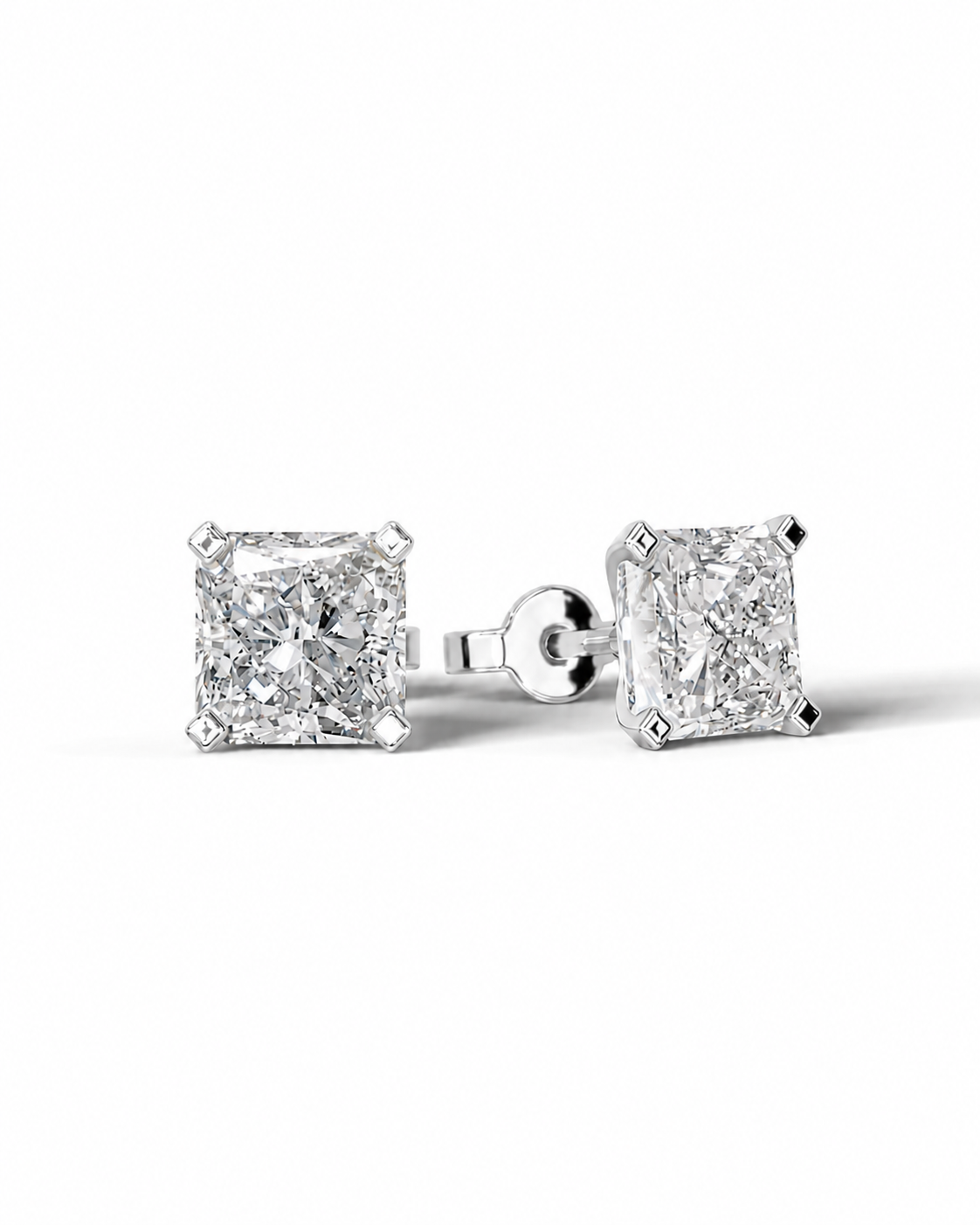 color_925_SIL,color_935_ARG,color_10K_WG, color_14K_WG &&A pair of princess-cut diamond stud earrings in a silver-toned setting, shown on a clean white background with one earring facing forward and the other angled to show the post and back.