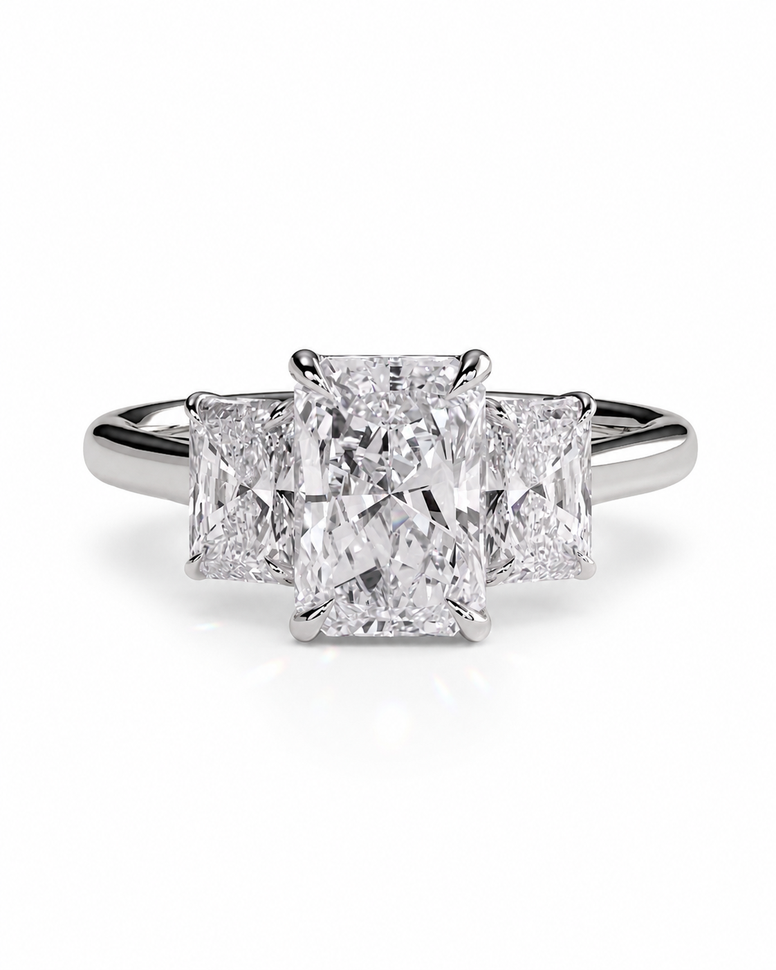 color_925_SIL,color_935_ARG,color_10K_WG, color_14K_WG &&A three-stone diamond ring featuring a large rectangular center diamond flanked by two smaller round diamonds, set in a polished silver-colored metal band on a clean white background.
