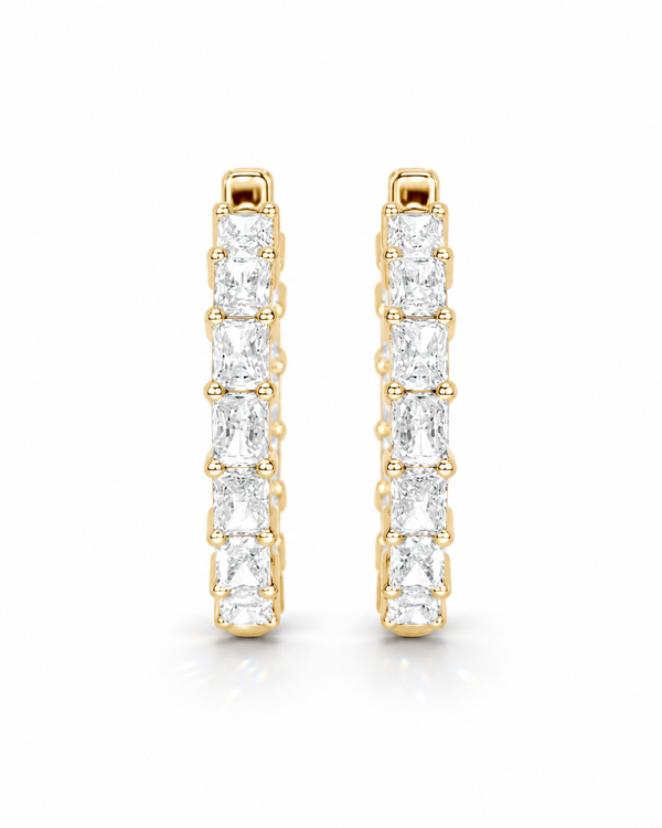 color_10K_YG, color_14K_YG &&A pair of gold huggie hoop earrings with a channel setting of baguette-cut clear gemstones, shown on a clean white background.