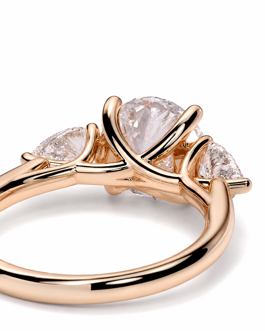 color_10K_RG, color_14K_RG &&
A close-up of a rose gold ring featuring a large pear-cut clear center stone and two smaller marquise-cut side stones, set in a polished branch-like band on a white background.