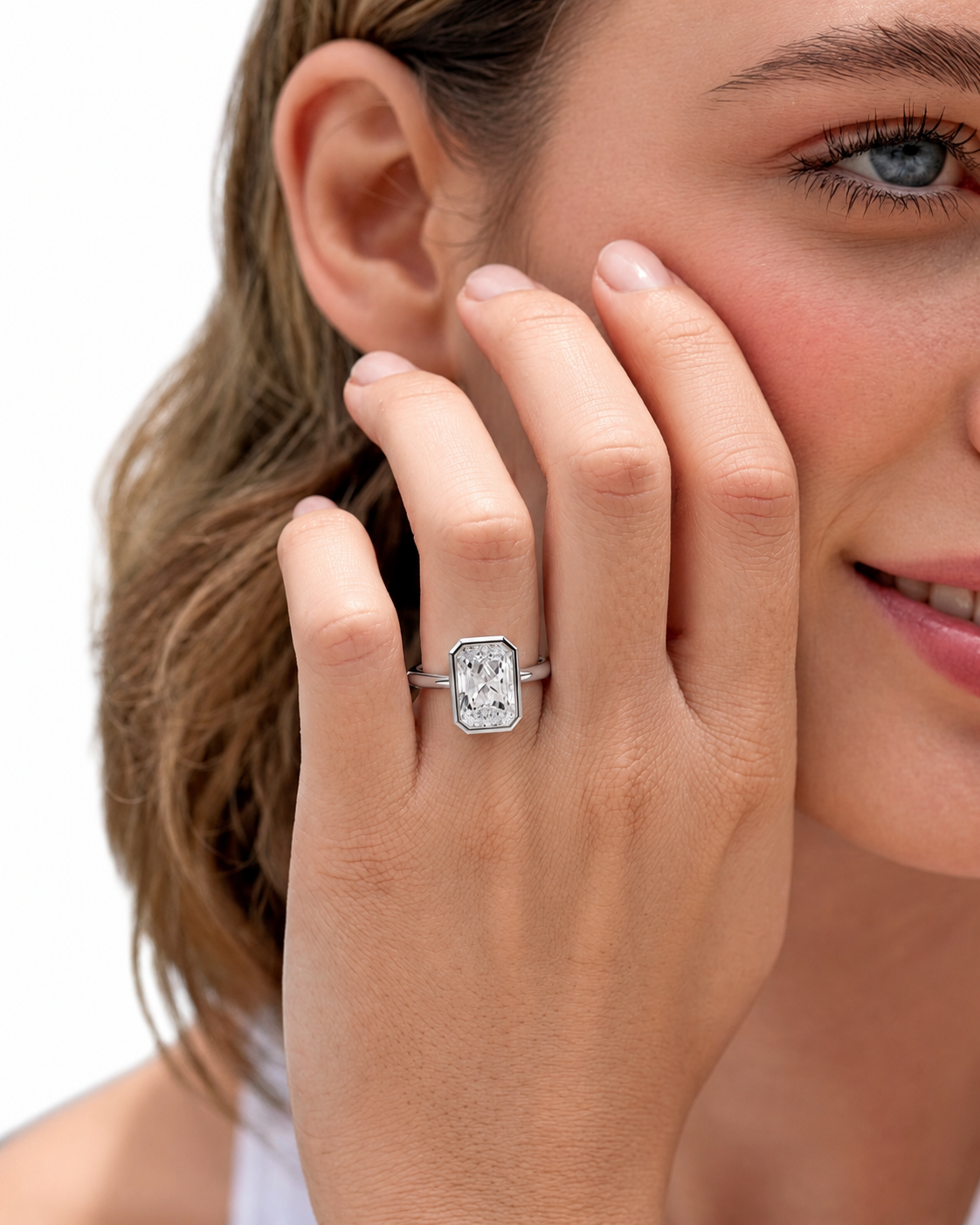 color_925_SIL,color_935_ARG,color_10K_WG, color_14K_WG &&A close-up lifestyle shot of a woman wearing a silver ring with a rectangular clear gemstone on her finger, set against a clean white background.