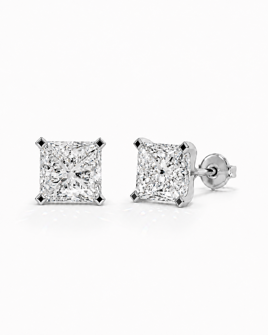color_925_SIL,color_935_ARG,color_10K_WG, color_14K_WG &&A pair of princess-cut diamond stud earrings in a silver four-prong setting, shown on a clean white background with one earring facing forward and the other angled to show the post and backing.